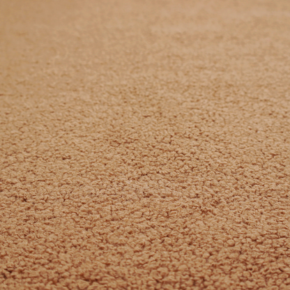 A textured camel brown bouclé upholstery fabric.