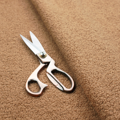 A textured camel brown bouclé upholstery fabric.