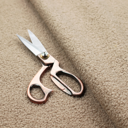 A textured khaki or warm taupe bouclé upholstery fabric.