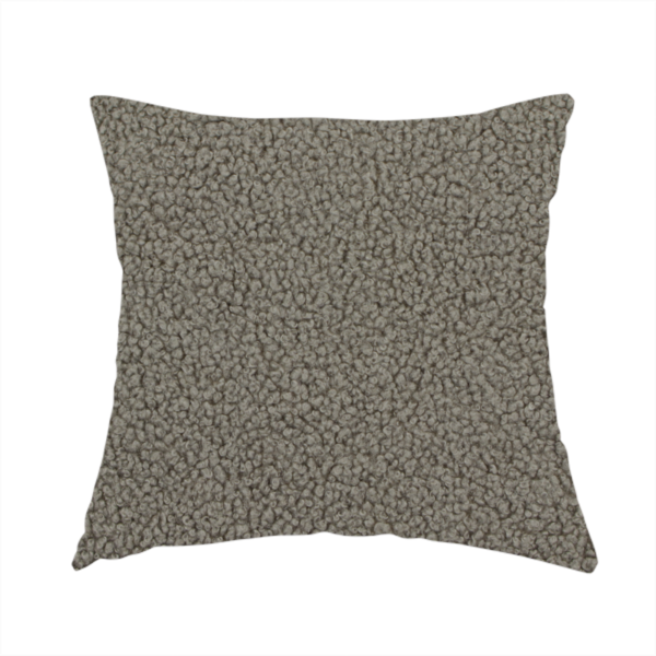 The fabric used to create this handmade cushion is a textured greyish-brown or elephant grey bouclé upholstery fabric.