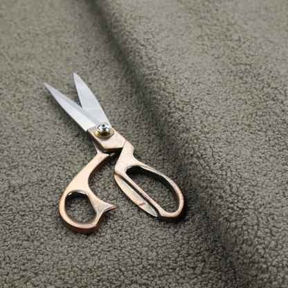 A textured greyish-brown or elephant grey bouclé upholstery fabric.