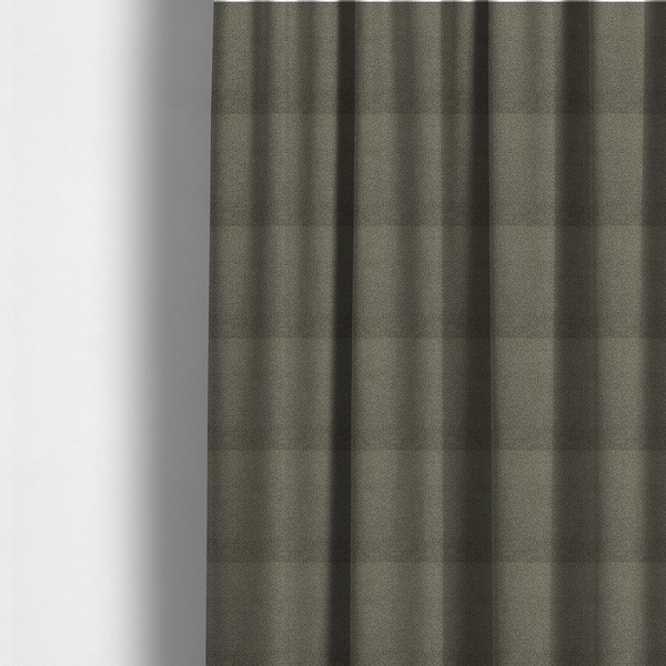 The fabric used to create these made-to-measure curtains is a textured greyish-brown or elephant grey bouclé upholstery fabric.