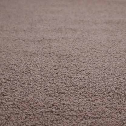 A textured rosy-brown or mauve bouclé upholstery fabric.