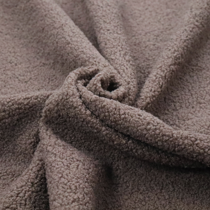 A textured rosy-brown or mauve bouclé upholstery fabric.