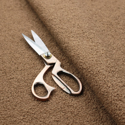 A textured medium brown or chestnut bouclé upholstery fabric.