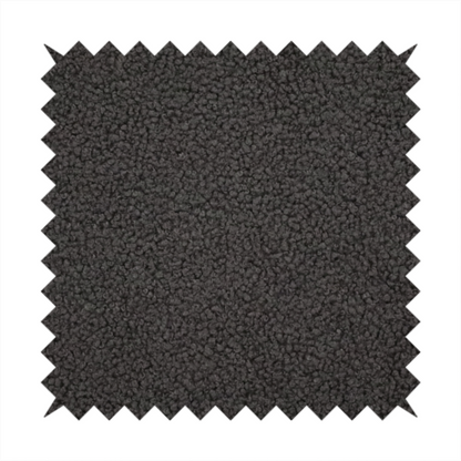 A textured charcoal grey bouclé upholstery fabric.
