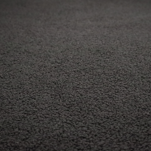 A textured charcoal grey bouclé upholstery fabric.