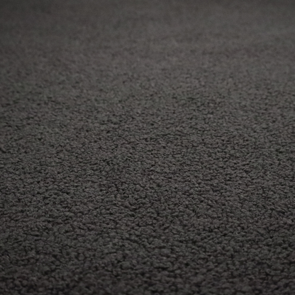 A textured charcoal grey bouclé upholstery fabric.