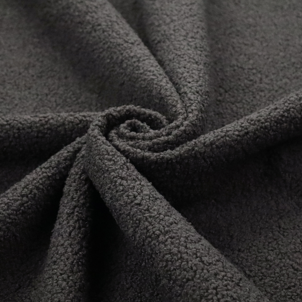 A textured charcoal grey bouclé upholstery fabric.