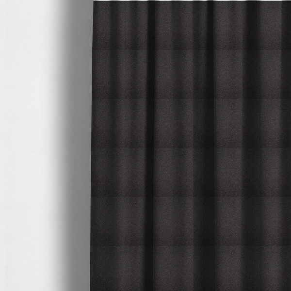 The fabric used to create these made-to-measure curtains is a textured charcoal grey bouclé upholstery fabric.