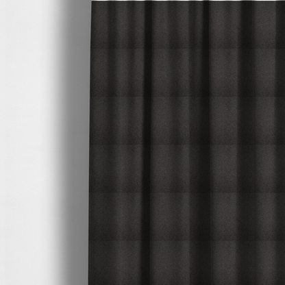 The fabric used to create these made-to-measure curtains is a textured charcoal grey bouclé upholstery fabric.