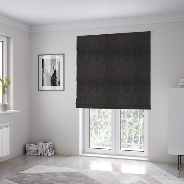 The fabric used to create these Roman blinds is a textured charcoal grey bouclé upholstery fabric.