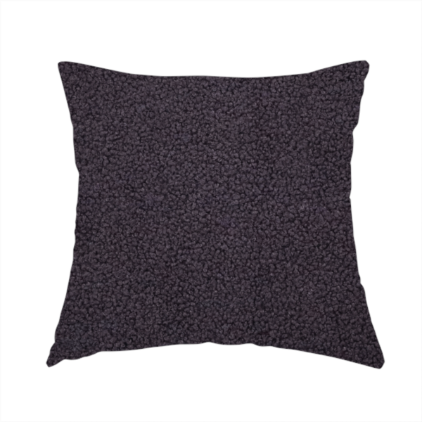 The fabric used to create this handmade cushion is a textured dark plum or deep charcoal purple bouclé upholstery fabric.
