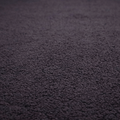A textured dark plum or deep charcoal purple bouclé upholstery fabric.