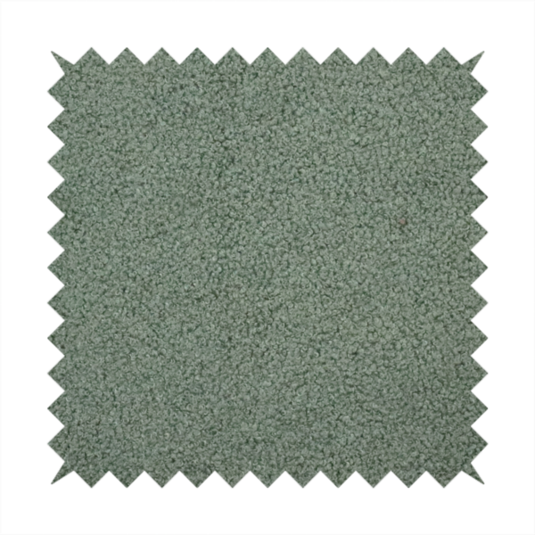 A textured sage green or muted jade bouclé upholstery fabric.