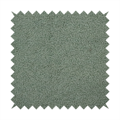 A textured sage green or muted jade bouclé upholstery fabric.