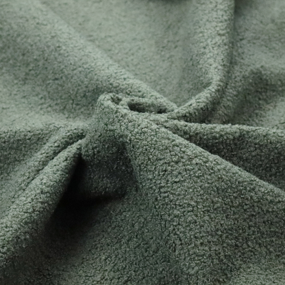 A textured sage green or muted jade bouclé upholstery fabric.