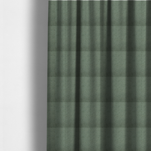 The fabric used to create these made-to-measure curtains is a textured sage green or muted jade bouclé upholstery fabric.