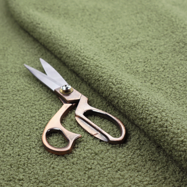 A dense, tightly looped, and pebbled surface characteristic of heavy wool or fleece, with subtle variations in light and shadow highlighting its nappy, tactile pile.