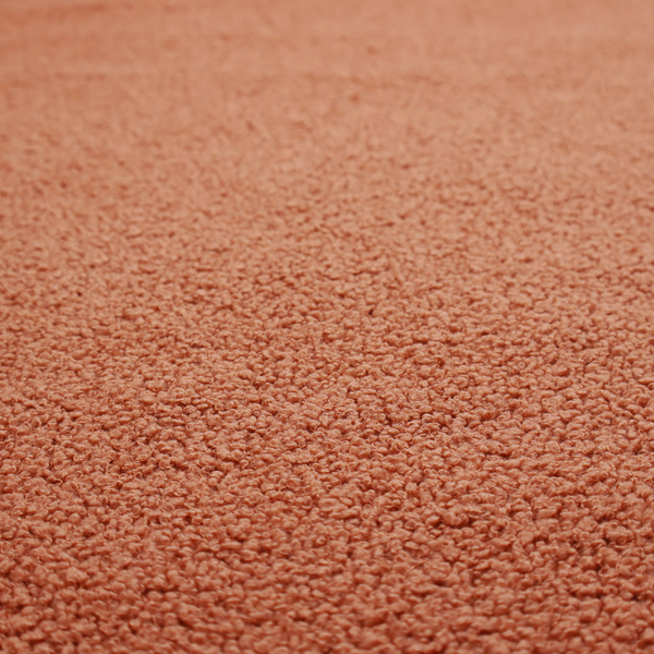 A terracotta or rust-orange boucle fabric texture.