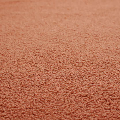 A terracotta or rust-orange boucle fabric texture.