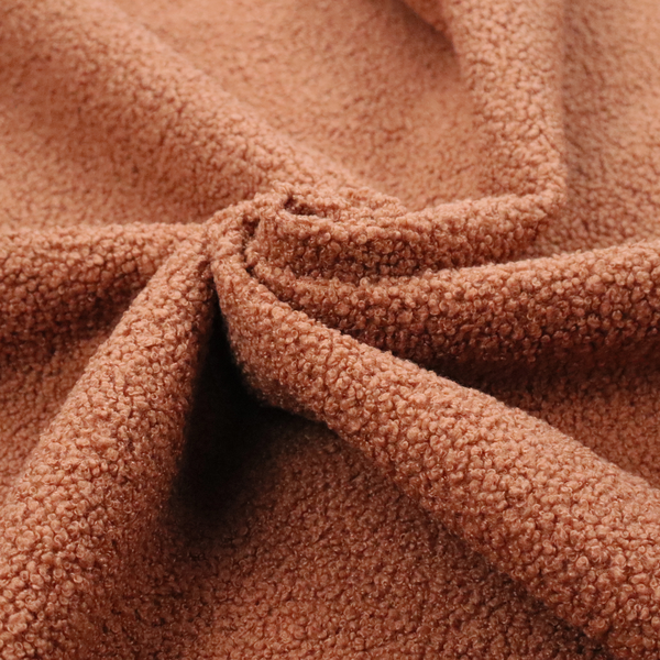 A terracotta or rust-orange boucle fabric texture.