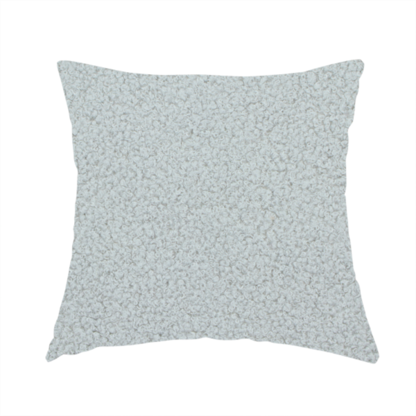 the fabric used to create this handmade cushion is a light grey or pale ice-blue boucle fabric texture.