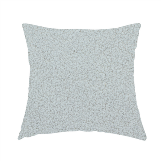 the fabric used to create this handmade cushion is a light grey or pale ice-blue boucle fabric texture.