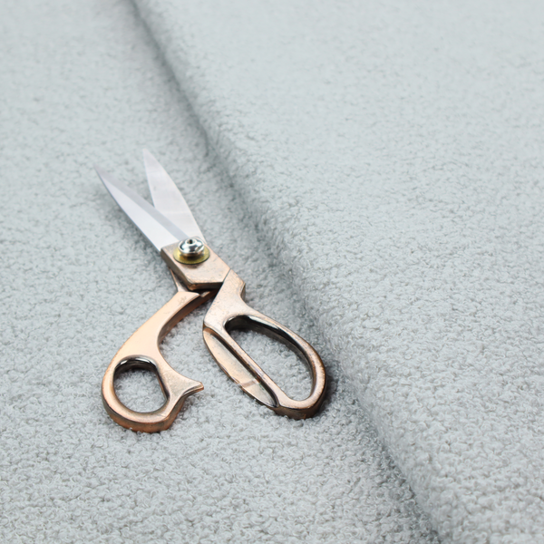 A light grey or pale ice-blue boucle fabric texture.