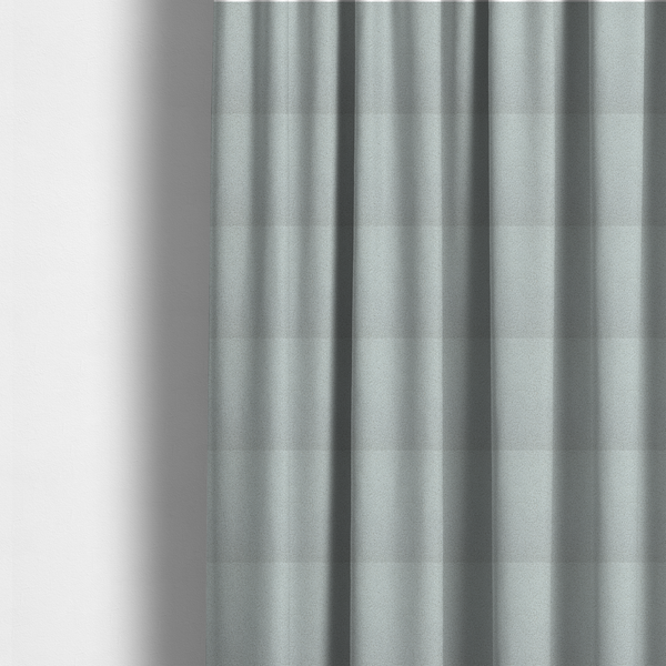 The fabric used to create these made-to-measure curtains is a light grey or pale ice-blue boucle fabric texture.