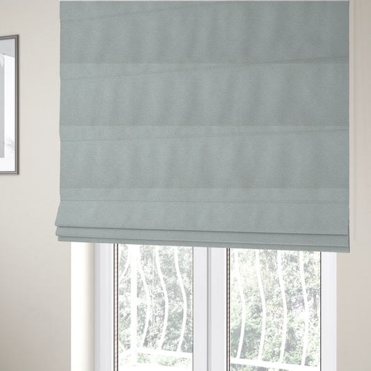 The fabric used to create these Roman blinds is a light grey or pale ice-blue boucle fabric texture.