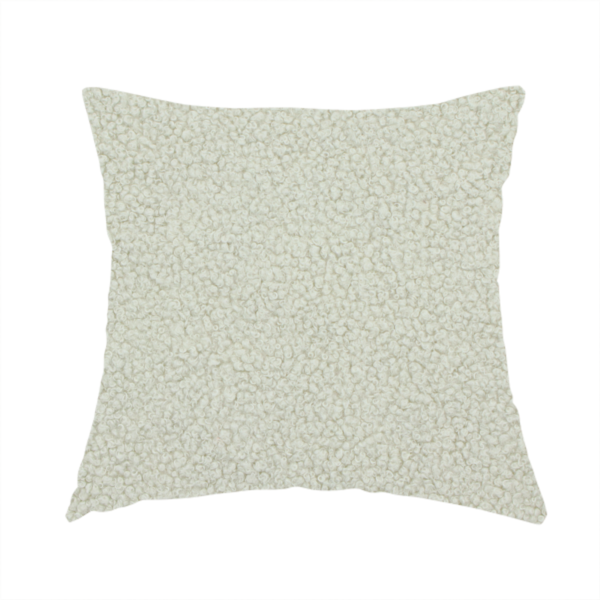 The fabric used to create this handmade cushion is a cream or off-white boucle fabric texture.