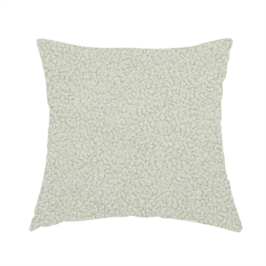 The fabric used to create this handmade cushion is a cream or off-white boucle fabric texture.