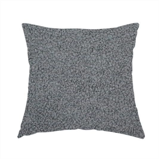 The fabric used to create this handmade cushion is a charcoal or slate grey boucle fabric texture.