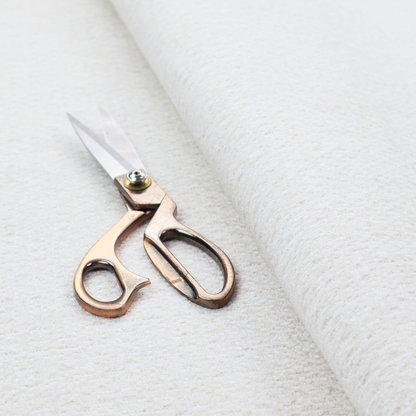 An off-white, finely textured woven upholstery fabric.