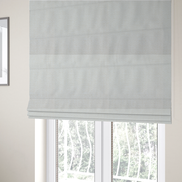 The fabric used to create these Roman blinds is a off-white, finely textured woven upholstery fabric.