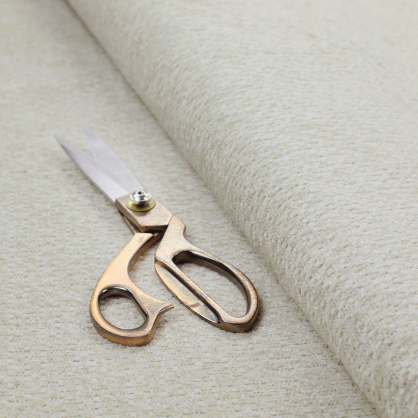 A cream-coloured, textured upholstery fabric.
