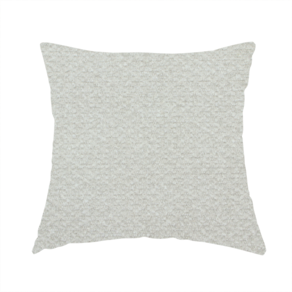 The fabric used to create this handmade cushion is a swatch of light grey, textured upholstery fabric.
