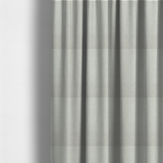 The fabric used to create these made-to-measure curtains is a swatch of light grey, textured upholstery fabric.