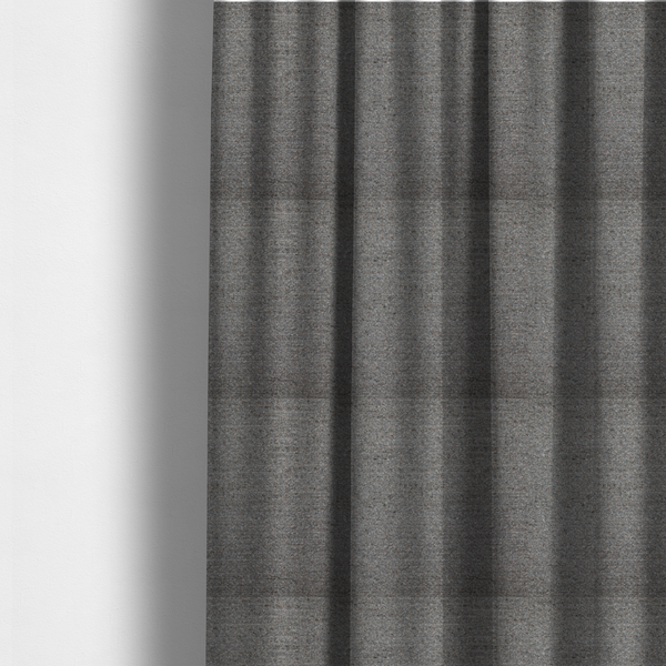 The fabric used to create these made-to-measure curtains is a dark grey, textured upholstery fabric.