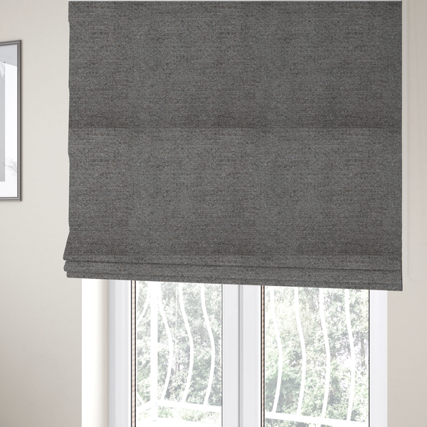 The fabric used to create these Roman blinds is a dark grey, textured upholstery fabric.