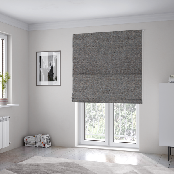 The fabric used to create these Roman blinds is a dark grey, textured upholstery fabric.
