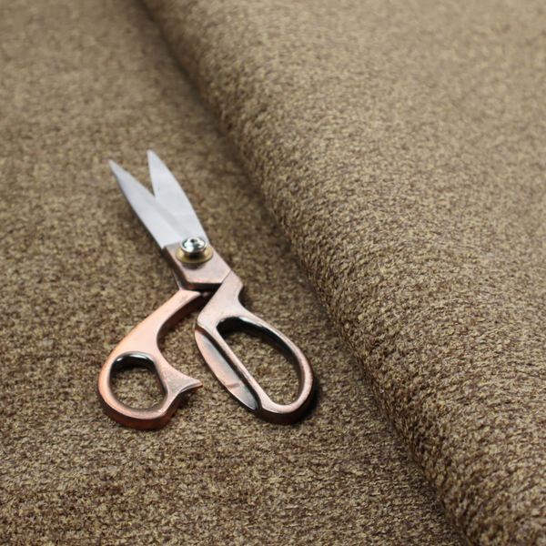 A multi-toned golden brown, textured upholstery fabric.