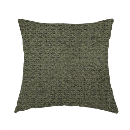 The fabric used to create this handmade cushion is a dark forest green, heavily textured upholstery fabric.
