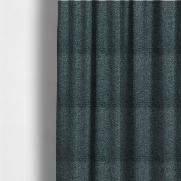 The fabric used to create these made-to-measure curtains is a dark teal or slate blue, textured upholstery fabric.