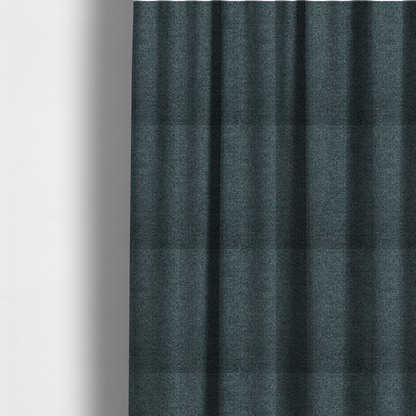 The fabric used to create these made-to-measure curtains is a dark teal or slate blue, textured upholstery fabric.
