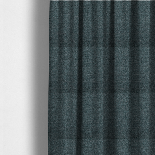 The fabric used to create these made-to-measure curtains is a dark teal or slate blue, textured upholstery fabric.