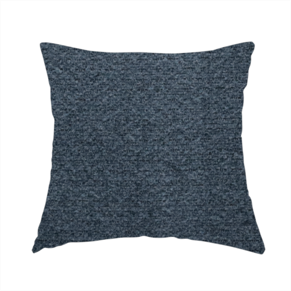 The fabric used to create this handmade cushion is a dark navy blue, heavily textured upholstery fabric.
