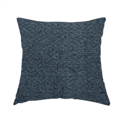 The fabric used to create this handmade cushion is a dark navy blue, heavily textured upholstery fabric.