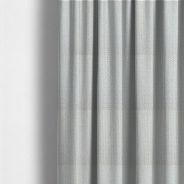 The fabric used to create these made-to-measure curtains is a swatch of textured cream white upholstery fabric.